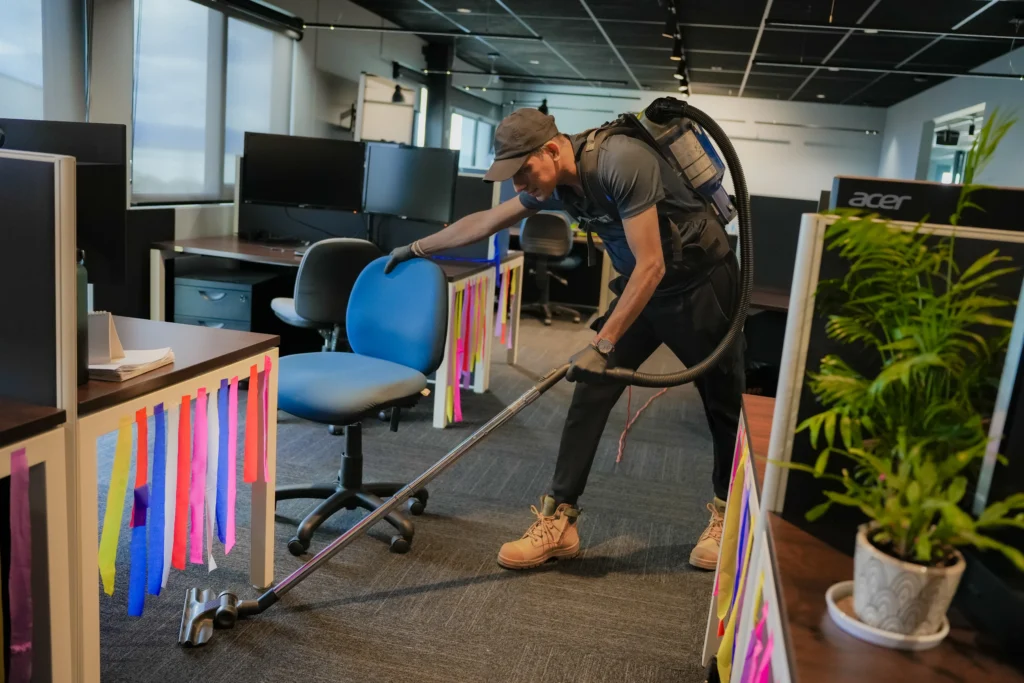 A commercial cleaner from Hobart Cleaning Company using a backpack vacuum to clean the floors of a corporate office, providing reliable commercial carpet cleaning services in Hobart.